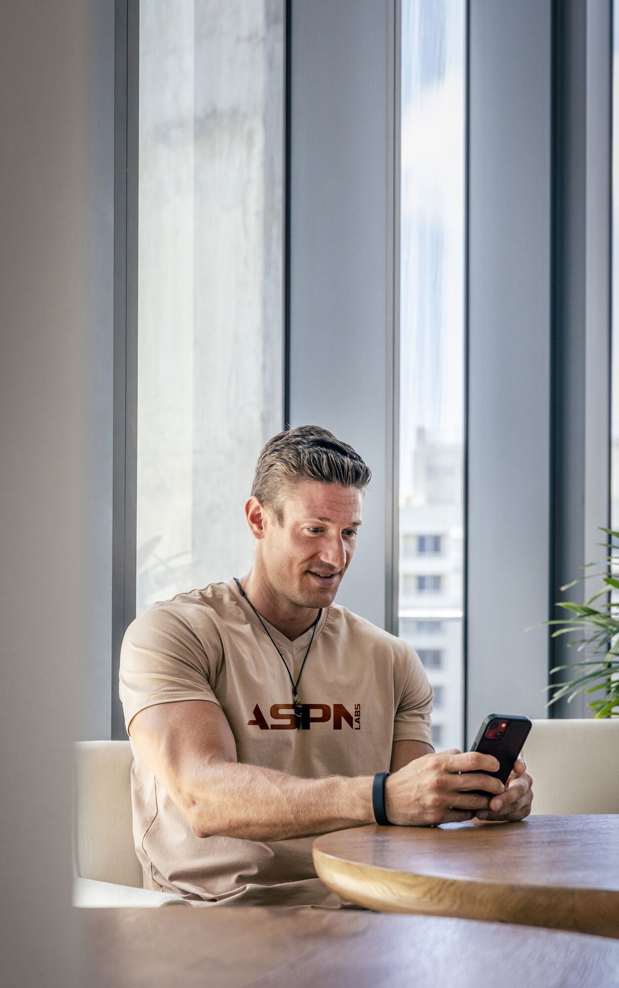Man in an ASPN shirt using his phone