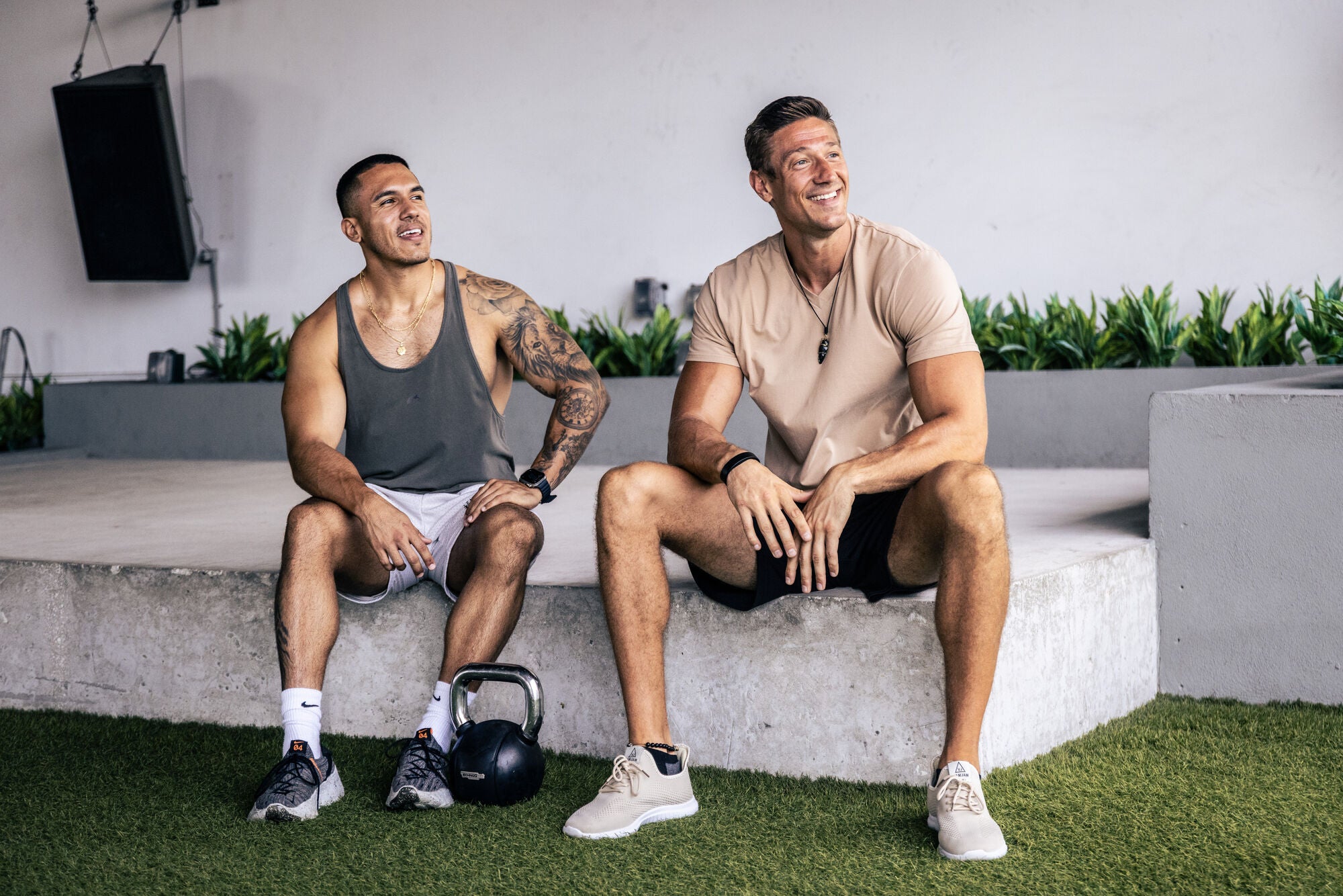 Two men sitting and talking in a gym space